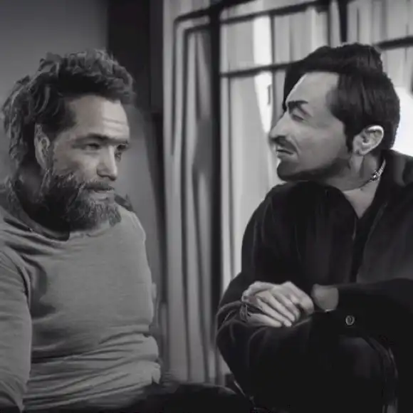 La imagen representa un momento franco durante una entrevista con Miguel Poveda, donde discute su profundo vínculo con Ángel y la influencia de su crianza artística en su colaboración.