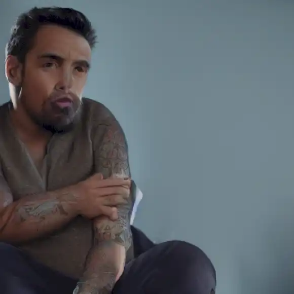La imagen debe representar un momento franco de una entrevista con Miguel Poveda discutiendo su estrecho vínculo con Ángel, así como su viaje para perfeccionar sus habilidades artísticas.